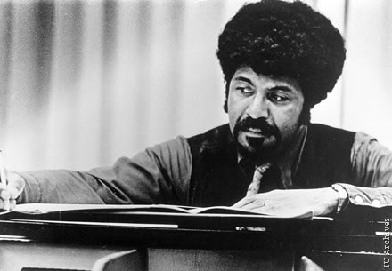 David Baker looking at music on a piano.